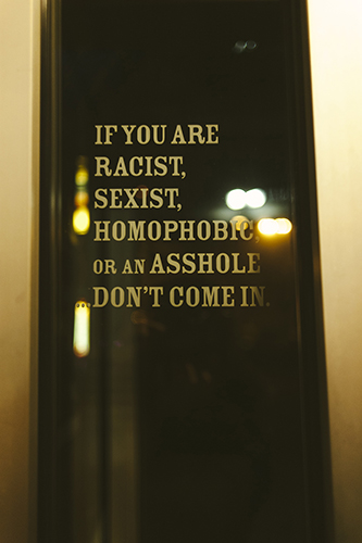 All three bar managers strive to cultivate an environment that isn’t conducive to aggressive behavior. This sign greets patrons of Atlas at the door. | Photo by Natasha Komoda