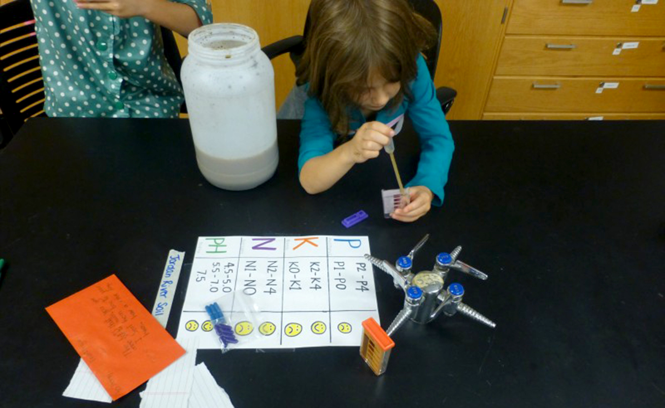 A young Saturday Science Quest student experiments with soil samples from Jordan River. | Courtesy photo