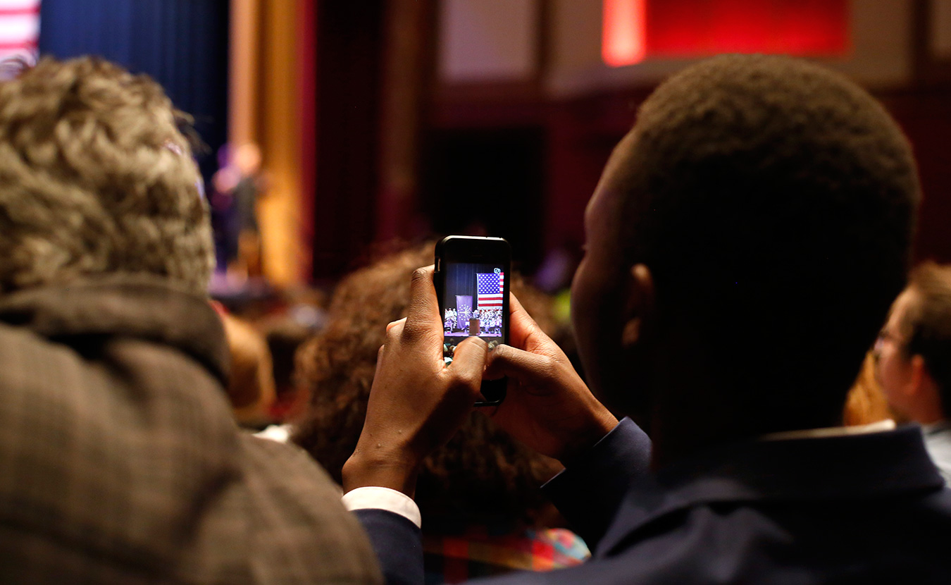 Stanley Njuguna, an IU freshman and a social media executive with IU Students for Bernie Sanders, captures the event on his phone. | Photo by TJ Jaeger