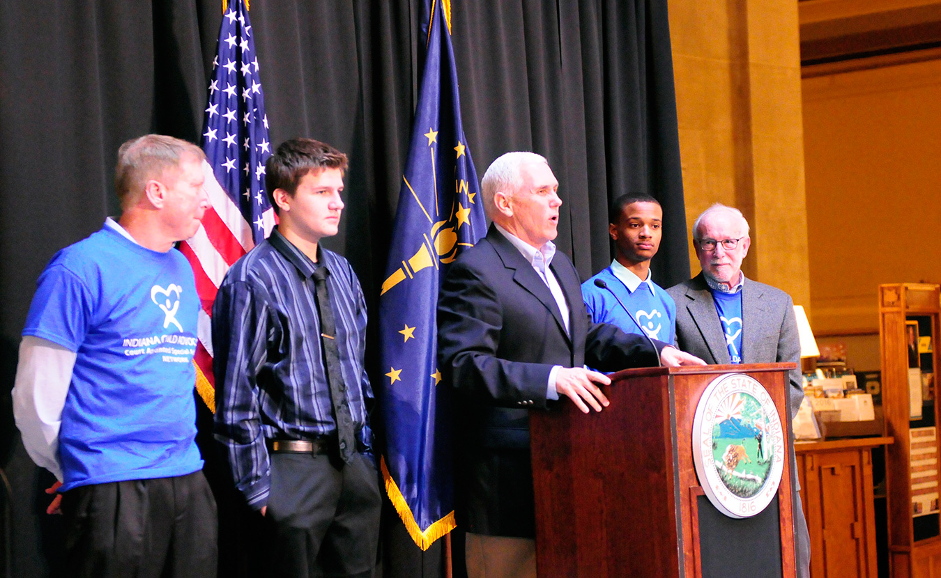 Phillips (second from right) and Shelton (right) stand on stage with Governor Mike Pence (center) at the CASA Day rally. | Photo by Ann Georgescu