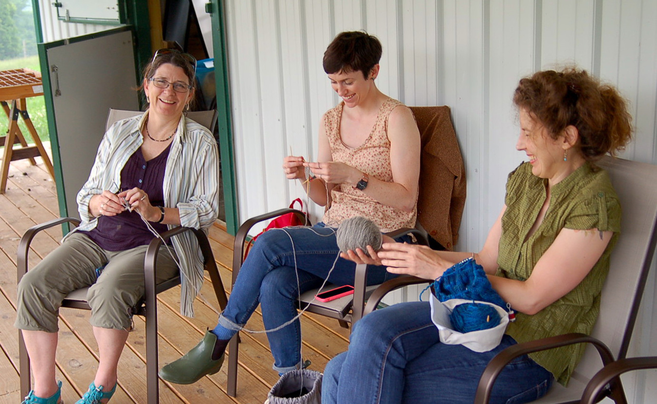 Lindsay (center) shares a laugh with fellow knitters, Faith Hawkins (left) and Karen Ellis, as they try out the Marble Hill Farm yarn for the first time. | Photo by Samuel Welsch Sveen