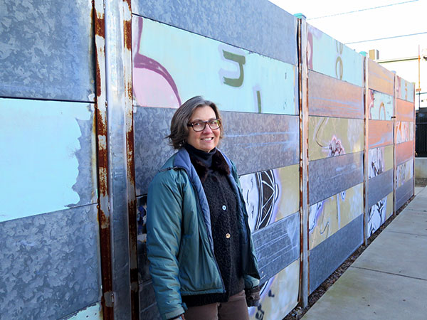 Cynthia Brubaker standing with the fence at Middle Way House. | Limestone Post