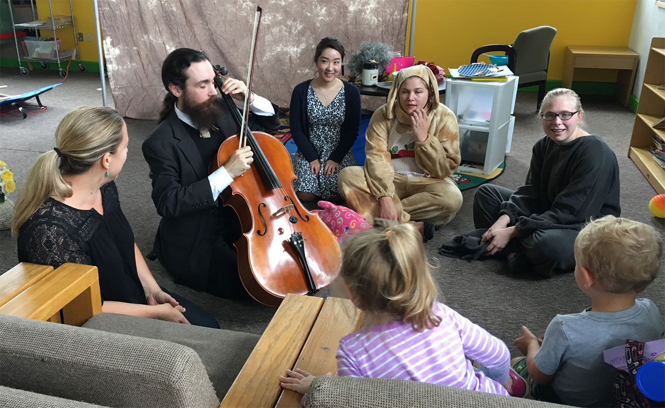 Kim Carballo (left) and Miles Edwards (second from left) teach children about the cello. | Courtesy photo