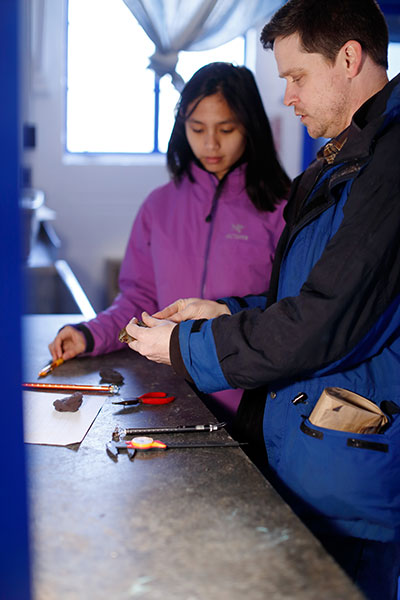 Fudickar, right, and student Lia Bobay attach a small USFWS band to a fox sparrow's leg at the Kent Farm Banding Station in Bloomington. The band has a unique number to allow them and other researchers to identify the bird if it is caught it in the future. They also take measurements before releasing the bird back into the wild so they can study the bird's migration patterns. | Photo courtesy of Eric Rudd, Indiana University Communications