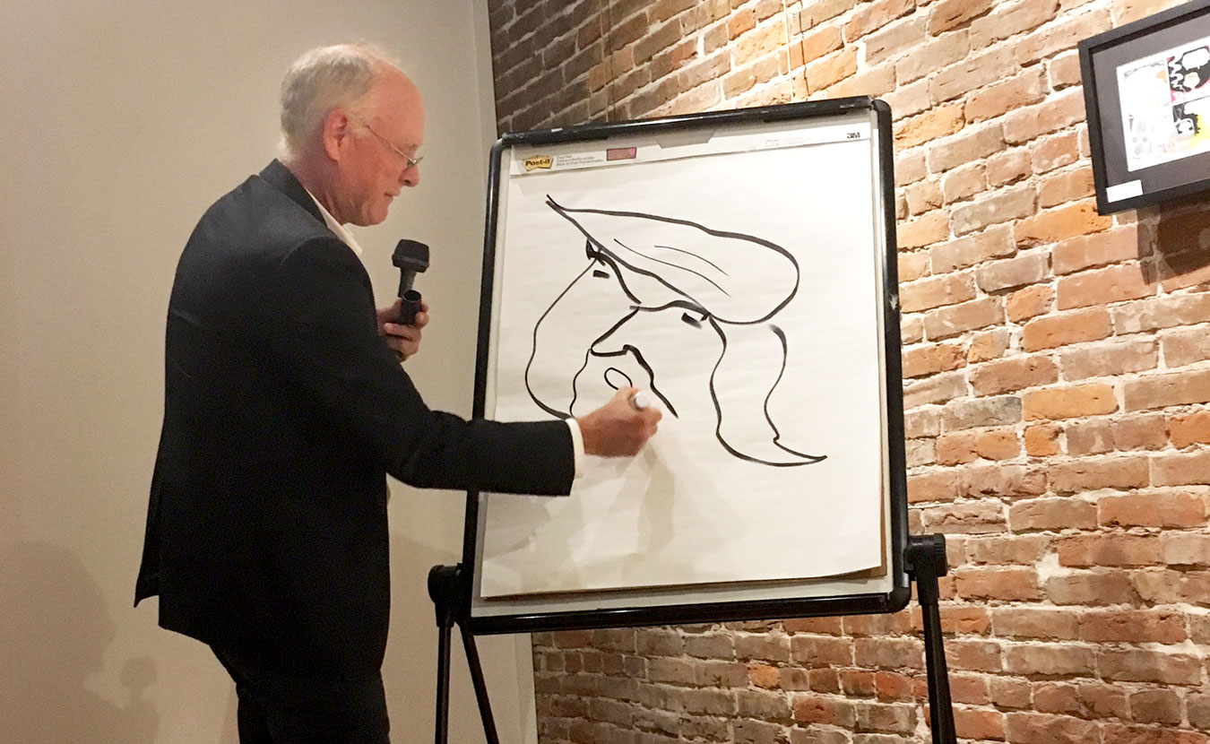 During Pett's performance at Thomas Gallery, he did a drawing demo, showing the audience his shorthand for rendering the last six presidents. | Photo by Devta Kidd