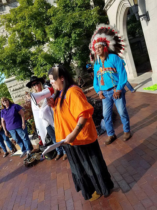 Writer Laura Martinez, wearing traditional Apache dress, speaks to a group of people at Sample Gates. As Halloween approaches, consider if your costume appropriates another's culture. | Courtesy photo