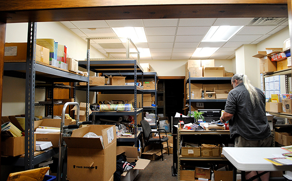 Jerry Iverson, The Language Conservancy’s customer support representative, sifts through boxes of booklets, DVDs, flashcards, and other materials produced at the business’s Bloomington headquarters.