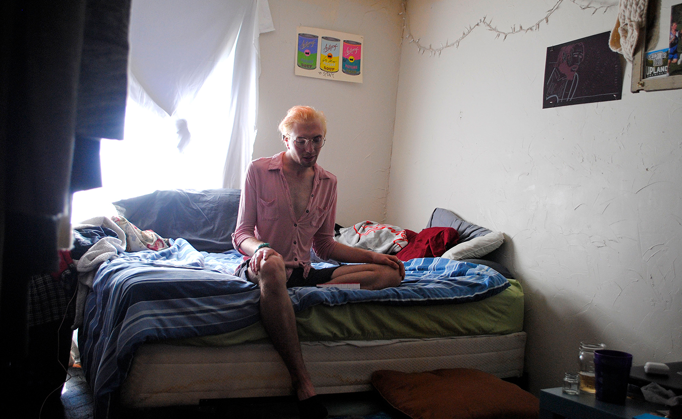 Bohuk sits in their room at 10:45 a.m. In 5 minutes, an alarm set on their phone will chime, signaling them to take their daily PrEP pill. Bohuk says, "I realized it’s just a pill. I am protecting myself and my partners. Why is there shame in that?” | Photo by Nicole McPheeters