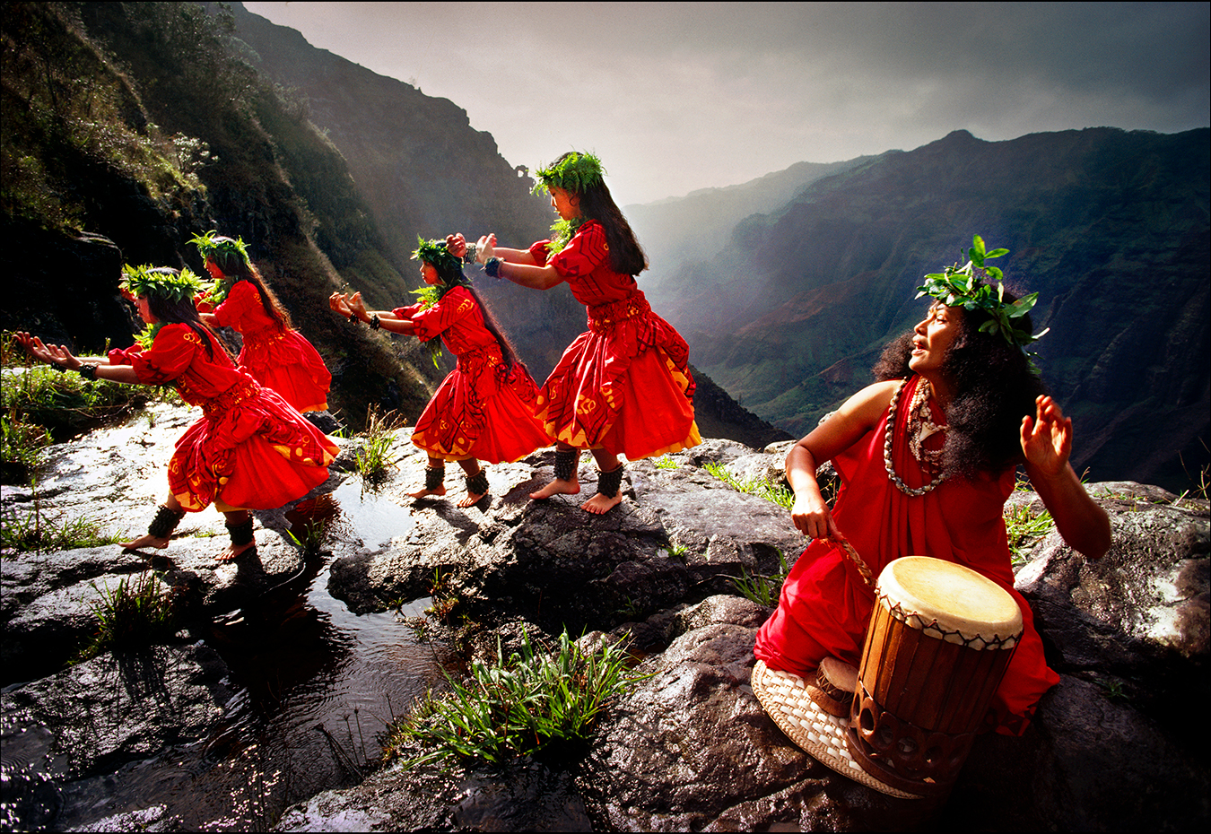 Performing the hula kahiko, or ancient Hawaiian hula, dancers blend simple footwork with hand gestures to illustrate the myths and histories of their families on the rim of the Waimea Canyon on Kauai. | © Steve Raymer / National Geographic Creative