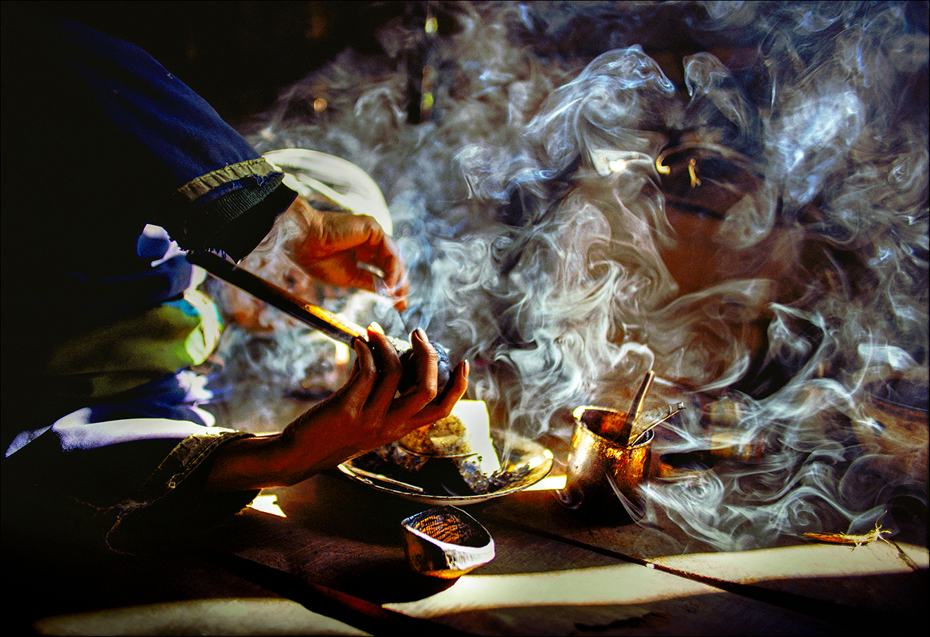 Engulfed in opium smoke, an addict of the Lisu ethnic hill tribe mixes a pipe of the narcotic in a village in the Golden Triangle of Southeast Asia, where Thailand, Laos, and Myanmar meet. The Golden Triangle was the largest supplier of opium in the world, but the region has since been eclipsed by the Golden Crescent — the poppy-growing area in and around Afghanistan. | © Steve Raymer / National Geographic Creative