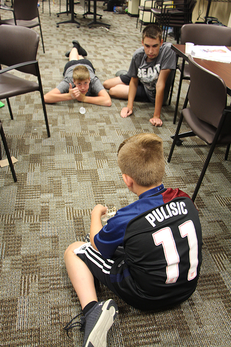 (Clockwise from upper left) Brayton Yoder, Dominic Wilson, and Brady Taylor created a device that launched a Ping Pong ball into a cup with precision at a Crane STEM Camp in June. | Photo by Patti Danner