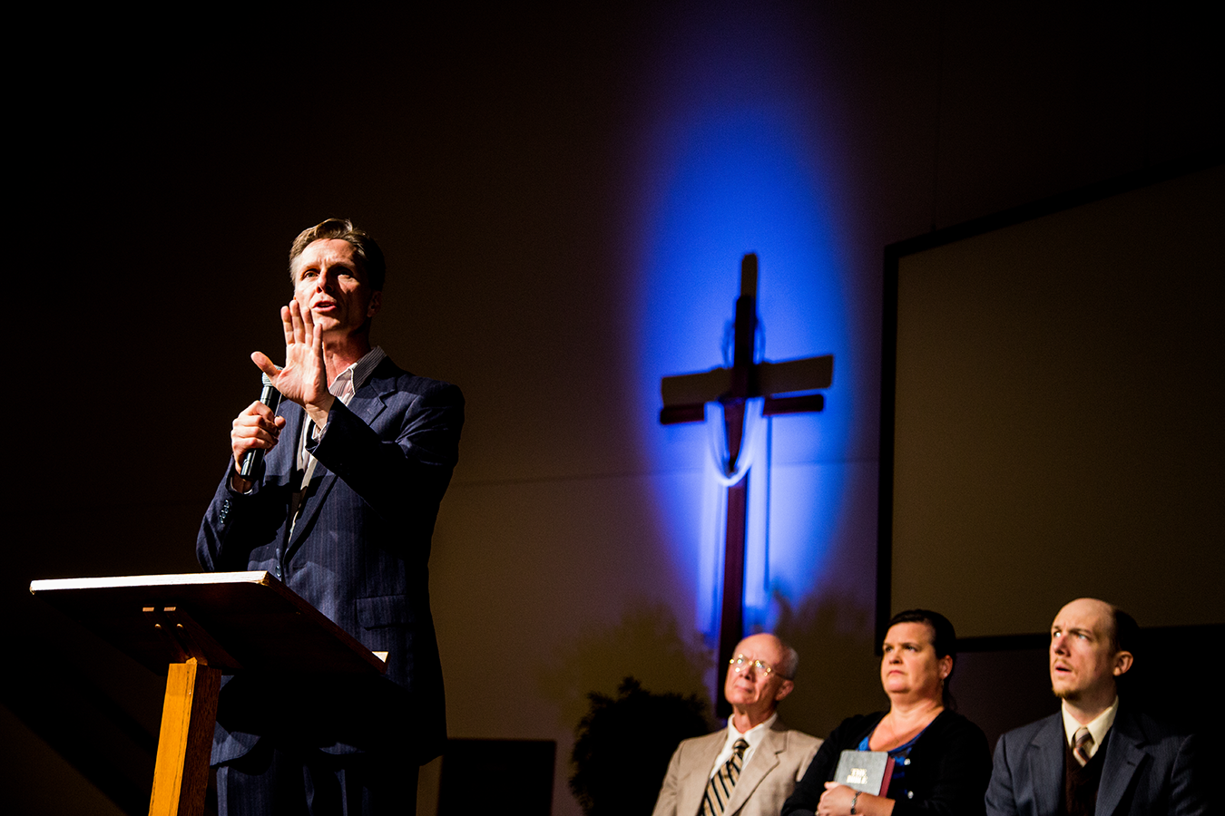 “How do you bridge the divide when you fundamentally disagree with someone on something that is a core part of your identity? We see the characters in the play struggling to stay connected as their belief systems drift further apart,” says Kate Galvin, Artistic Director of Cardinal Stage. From left to right, actors James Krag (Pastor), Ken Ganza (Elder), Shannon O’Connor Starks (Wife), and Liam Castellan (Associate Pastor). | Photo by Blueline
