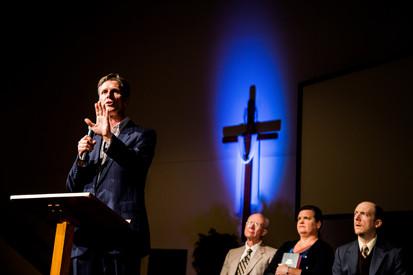 “How do you bridge the divide when you fundamentally disagree with someone on something that is a core part of your identity? We see the characters in the play struggling to stay connected as their belief systems drift further apart,” says Kate Galvin, Artistic Director of Cardinal Stage. From left to right, actors James Krag (Pastor), Ken Ganza (Elder), Shannon O’Connor Starks (Wife), and Liam Castellan (Associate Pastor). | Photo by Blueline