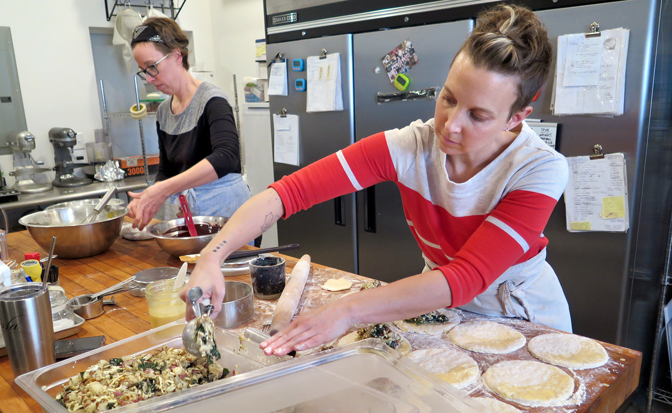 Jenson, left, and Armstrong — who are making peanut butter brownies and hand pies, respectively, in their bakery on South Washington Street — say that when they slow down and enjoy their food, they tend to feel more satisfied and sometimes eat less. | Limestone Post