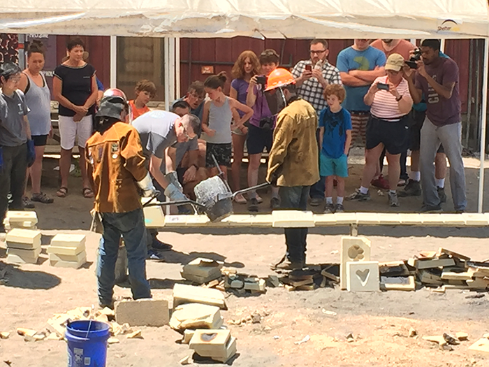 Visitors watch as aluminum is poured from a crucible into sand scratch blocks. | Photo by Laurie D. Borman